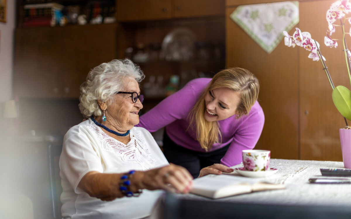 Young woman spending time with her elderly grandmother at home