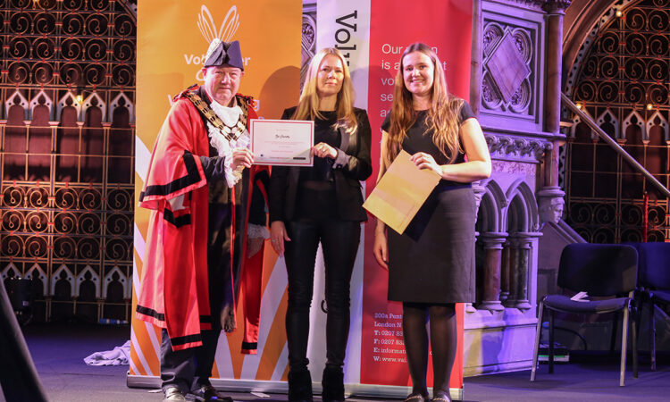 Zoe stood on stage at the VAI awards holding her certificate, with the Mayor of Islington on her left and another lady on her right