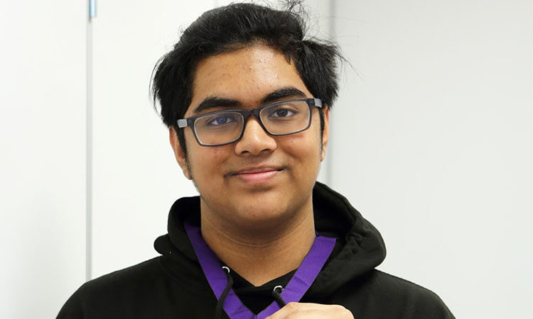 Head and shoulder shot of youth councillor Areeb wearing a medal and glasses, smiling to camera