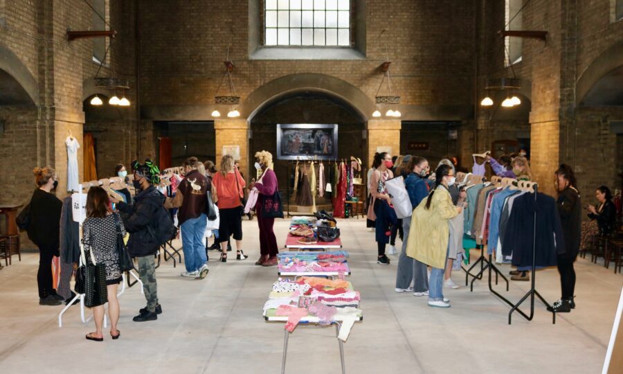 People pick through clothes rails at a clothes swap event
