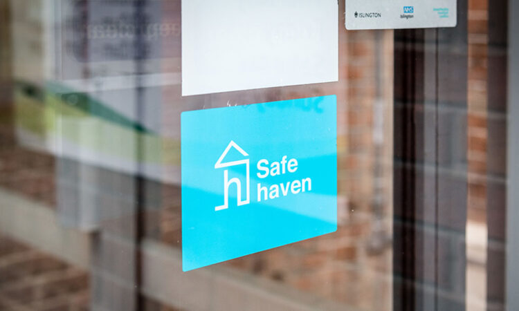 Safe havens sticker in window: a blue background with a white outline of a house