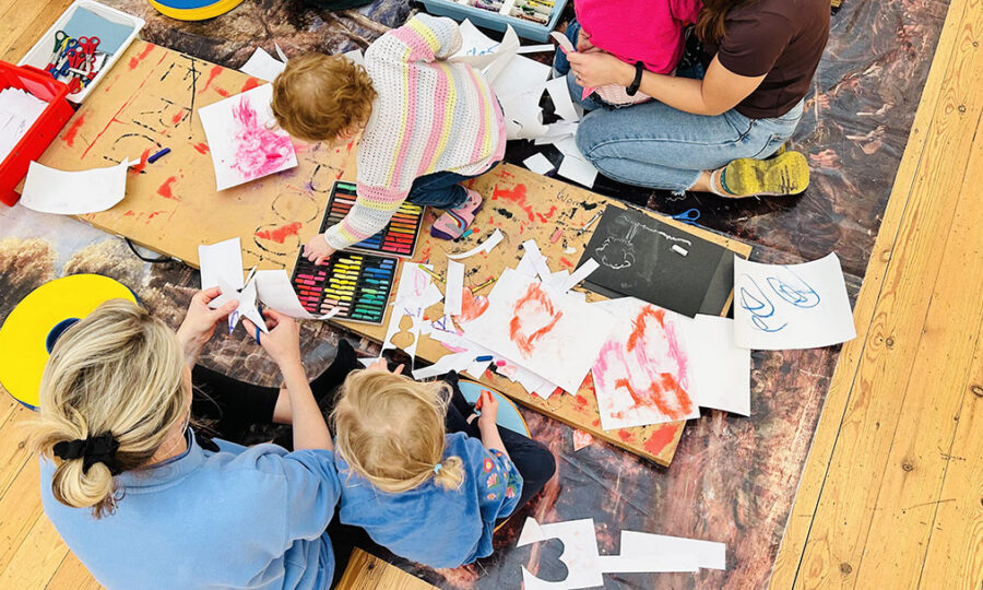 Aerial view of a family doing colourful artwork on the floor
