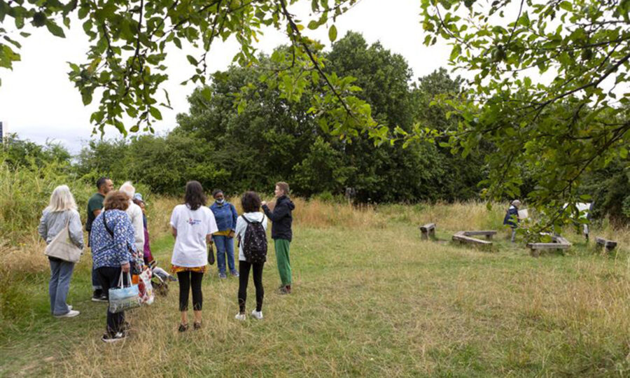 A group of people on a guided walk in a green field