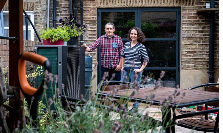 A man and woman in their garden smiling at the camera