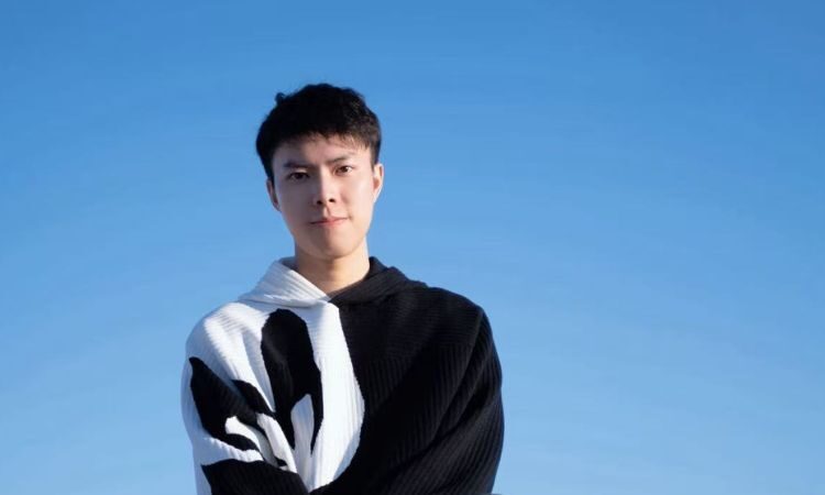 Man looking at camera thoughtfully with blue sky background