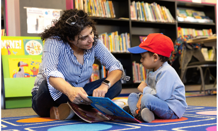 Woman reading to young child in library