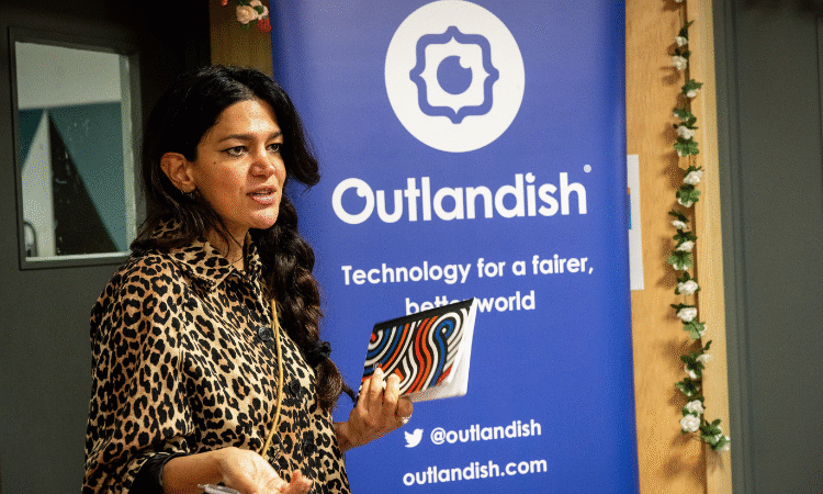 A woman wearing a leopard print shirt and hair in a plait giving a speech