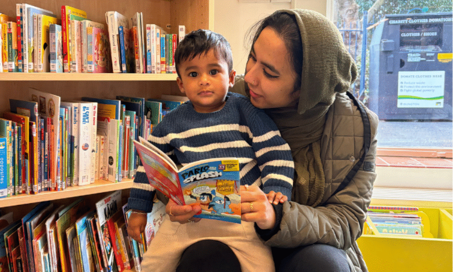A mother reading to her child in the library