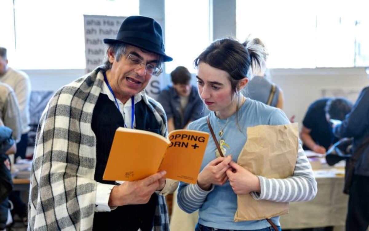 A man and woman holding up a book and reading it together